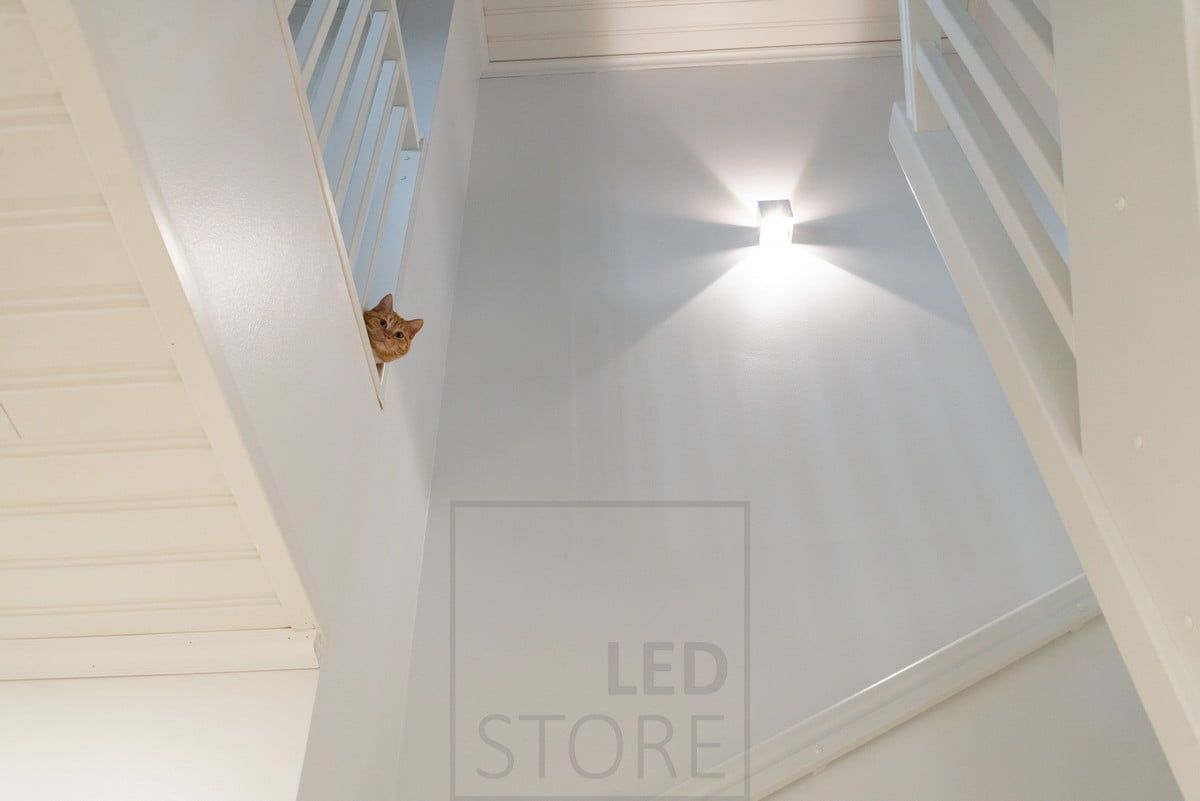 FUNK wall light in white illuminating the staircase, up and down and dimmable.